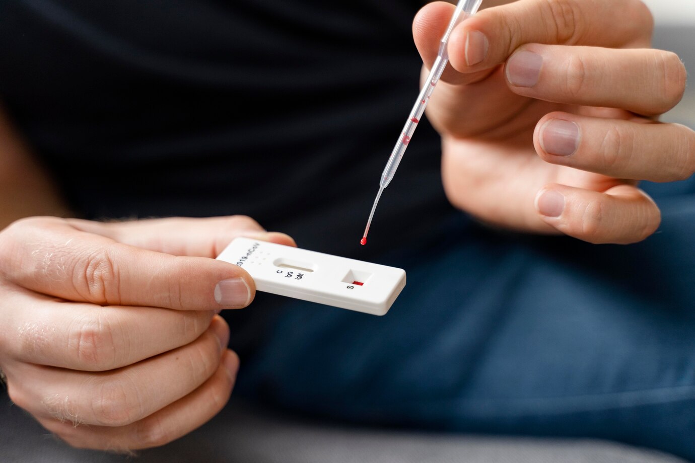 A person holding a rapid test device with a visible result in a well-lit environment