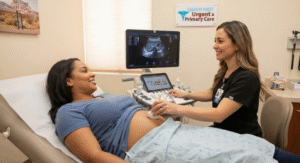 A medical professional performing an ultrasound scan on a smiling female patient in an exam room at Sahara West Urgent Care & Primary Care in Las Vegas, with the clinic logo visible.